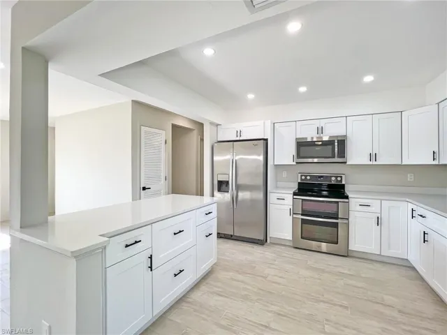 Kitchen featuring white cabinetry, light hardwood / wood-style flooring, and stainless steel appliances