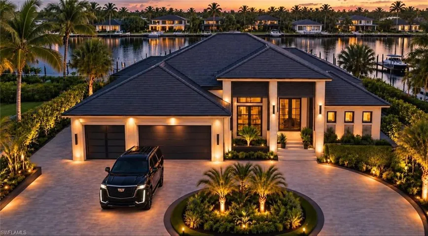 Waterfront residence with a circular drive, two-car garage, and mature landscaping