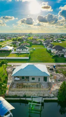 Canal-front property with a new construction residence under development featuring a boat dock and lift