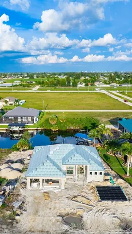 New construction residence featuring a light blue tile roof, integrated garage, and a waterfront location with a private dock