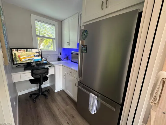 Office featuring built in desk and dark hardwood / wood-style flooring