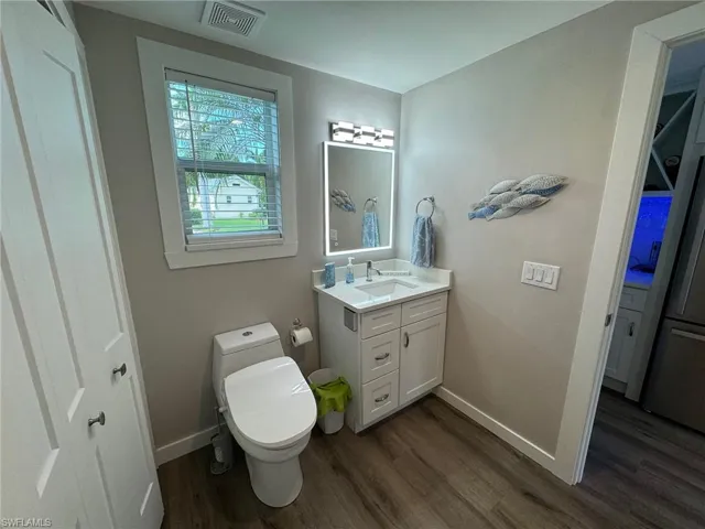 Bathroom with vanity, toilet, and hardwood / wood-style flooring