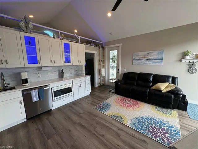 Kitchen with white cabinets, stainless steel appliances, sink, dark hardwood / wood-style floors, and ceiling fan