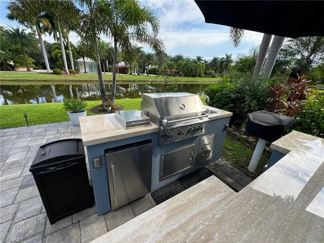 View of patio / terrace featuring exterior kitchen, a grill, and a water view