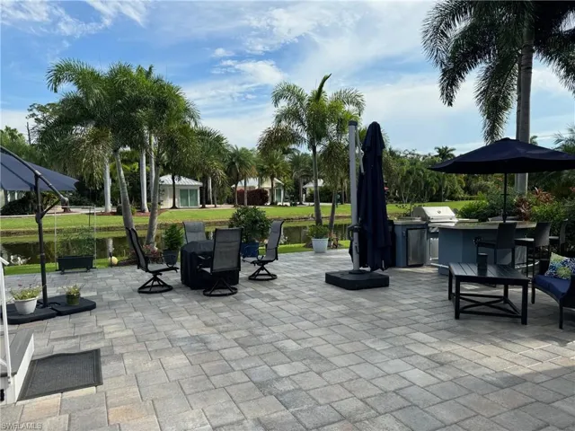 View of patio / terrace with a water view, an outdoor kitchen, and a grill