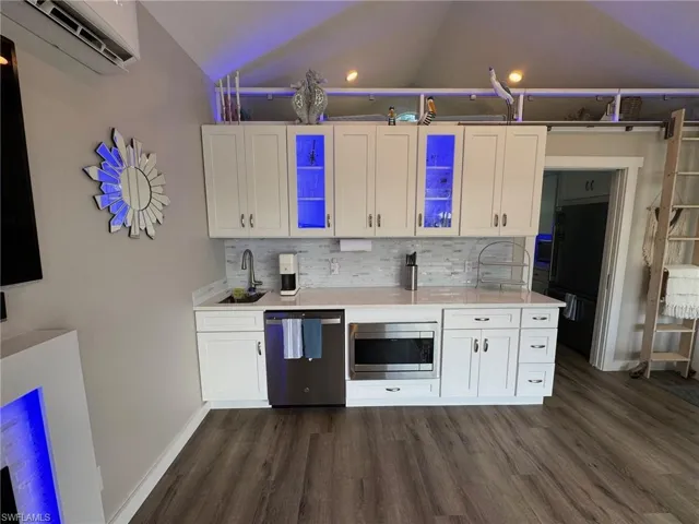 Kitchen featuring appliances with stainless steel finishes, dark hardwood / wood-style flooring, and white cabinetry