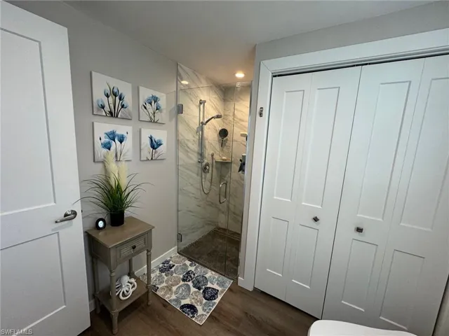 Bathroom featuring hardwood / wood-style floors and an enclosed shower