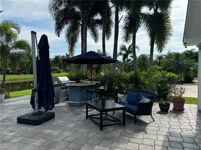 View of patio featuring an outdoor living space, grilling area, an outdoor kitchen, and a water view
