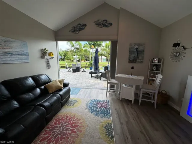 Living room with lofted ceiling and wood-type flooring