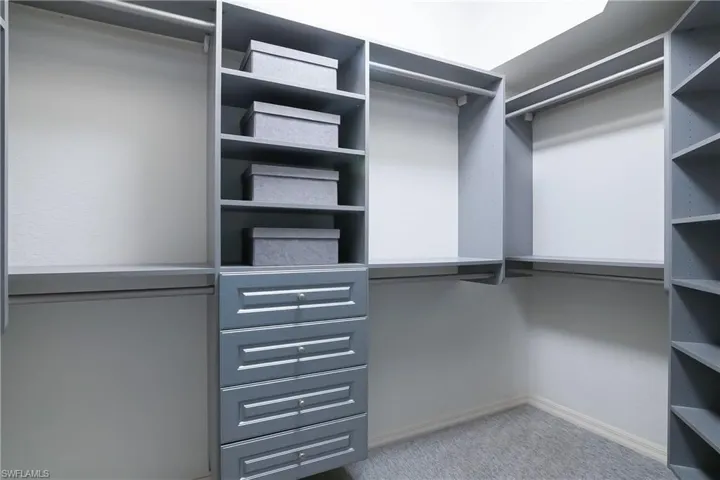 Spacious master closet featuring custom built-ins