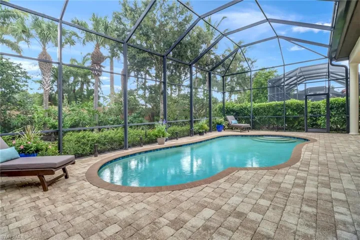 View of swimming pool featuring a patio area and a lanai