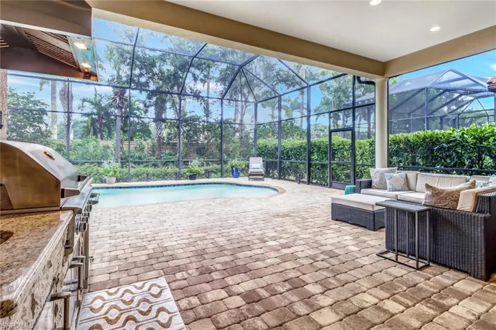 View of pool with a lanai, a patio area, and an outdoor living space
