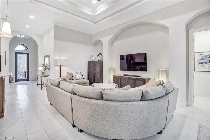 Living room featuring a towering ceiling and light tile patterned floors
