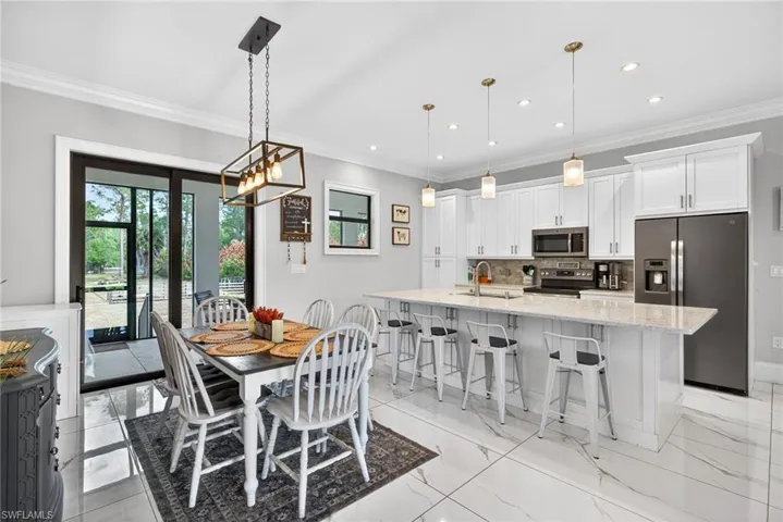 Dining area with crown molding, plenty of natural light, light marble finish flooring, and recessed lighting