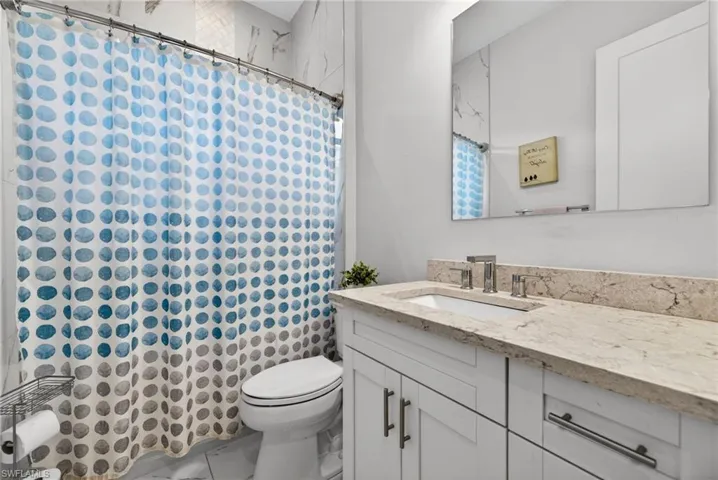 Bathroom with vanity and curtained shower