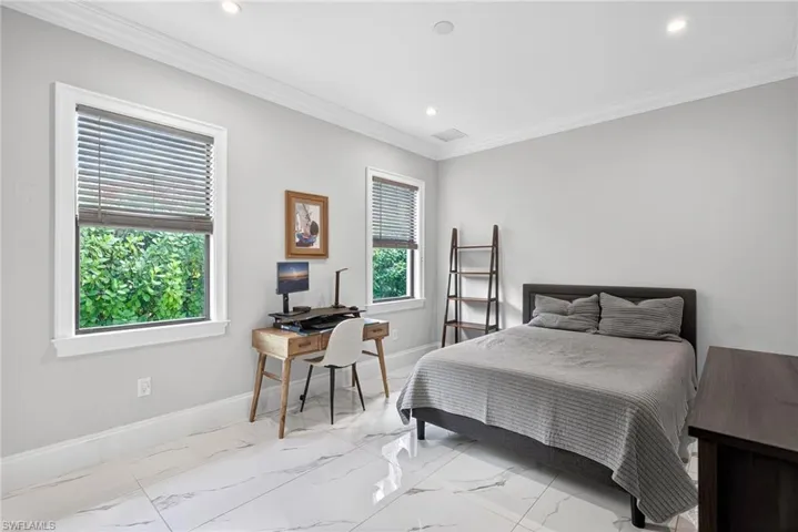 Bedroom featuring ornamental molding, an office area, recessed lighting, and light marble finish flooring