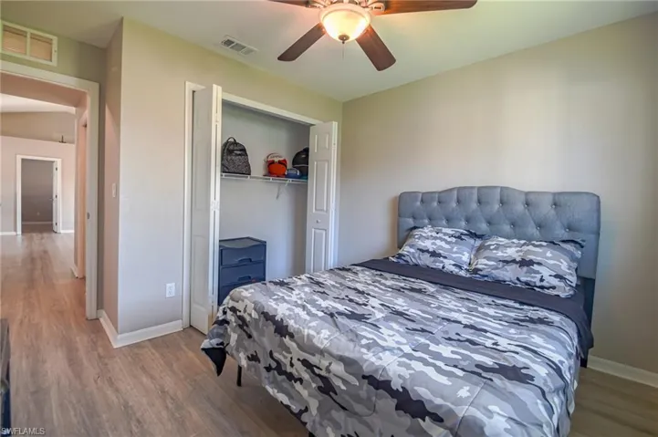 Bedroom featuring hardwood / wood-style floors, a closet, and ceiling fan