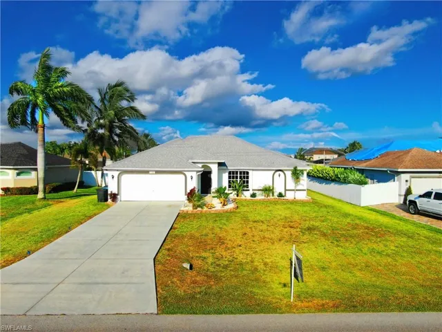 Single story home featuring a garage and a front lawn