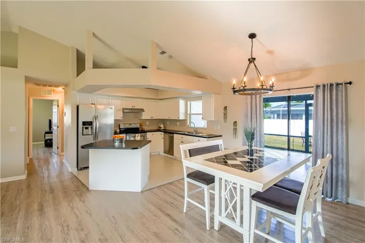 Kitchen with light hardwood / wood-style floors, white cabinets, and stainless steel appliances