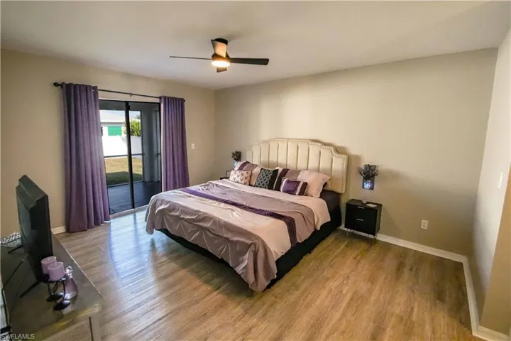 Bedroom featuring ceiling fan, access to exterior, and hardwood / wood-style flooring