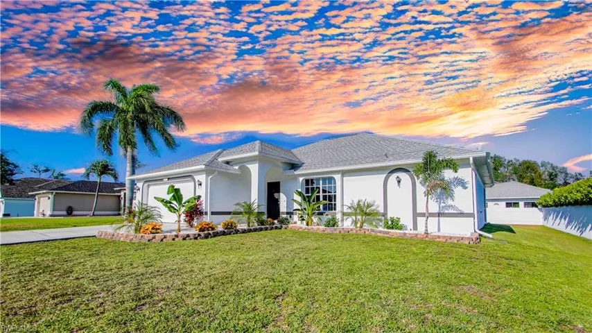 View of front of property with a garage and a lawn
