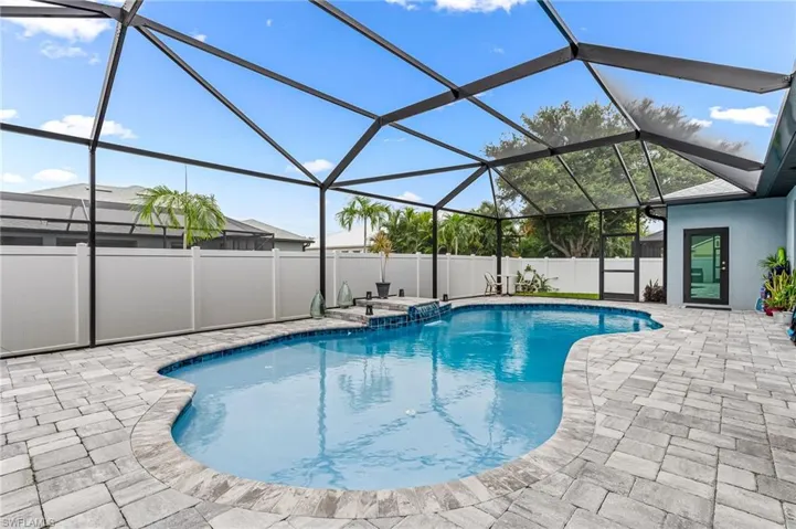 View of swimming pool with a patio and glass enclosure