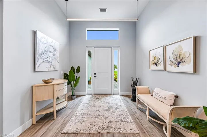 Foyer with wood-type flooring and high vaulted ceiling