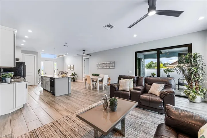Living room featuring sink, a wealth of natural light, ceiling fan, and light wood-type flooring