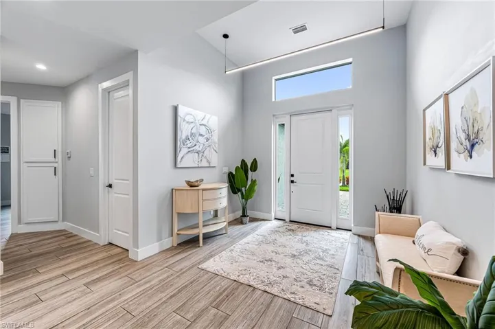 Entrance foyer featuring light hardwood / wood-style flooring and a high ceiling