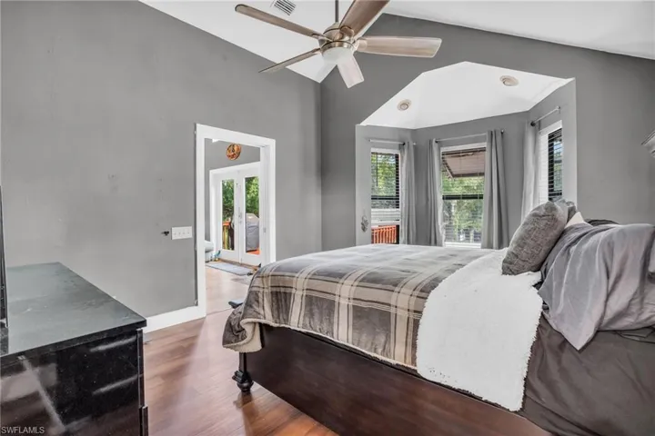 Bedroom featuring access to outside, wood-type flooring, and ceiling fan