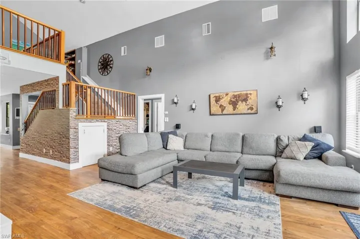 Living room featuring a high ceiling and wood-type flooring