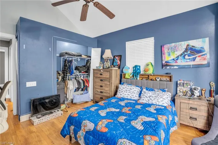Bedroom with ceiling fan, hardwood / wood-style floors, a closet, and vaulted ceiling