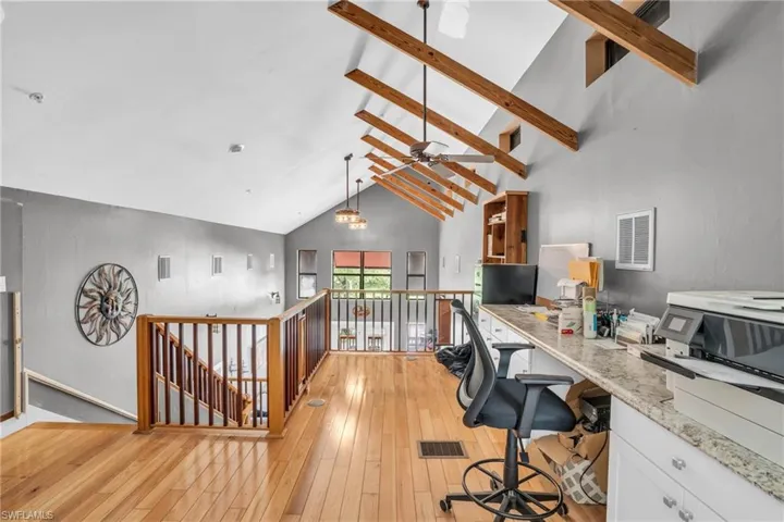 Home office with high vaulted ceiling, ceiling fan, light wood-type flooring, and beam ceiling