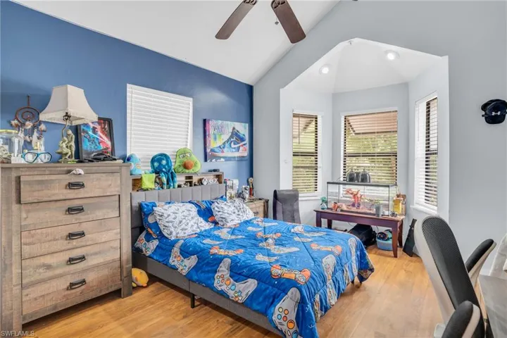 Bedroom with lofted ceiling, hardwood / wood-style flooring, and ceiling fan