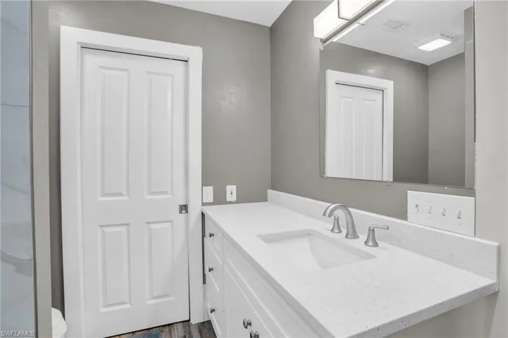 Bathroom with vanity, toilet, and wood-type flooring