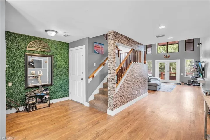 Stairs with hardwood / wood-style floors and french doors