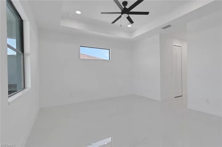 Spare room with recessed lighting, marble finish floors, a raised ceiling, and ceiling fan
