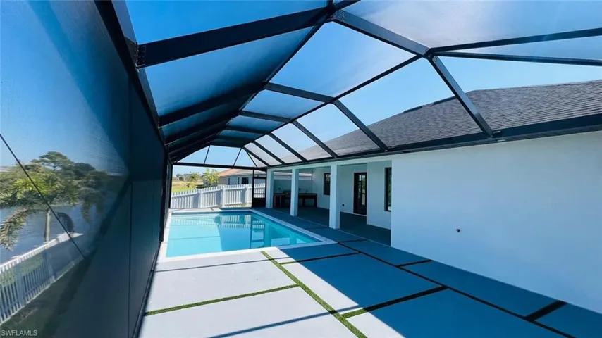 View of pool featuring a patio and glass enclosure