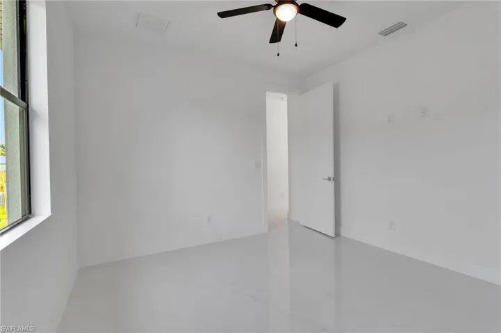 Spare room featuring ceiling fan and baseboards