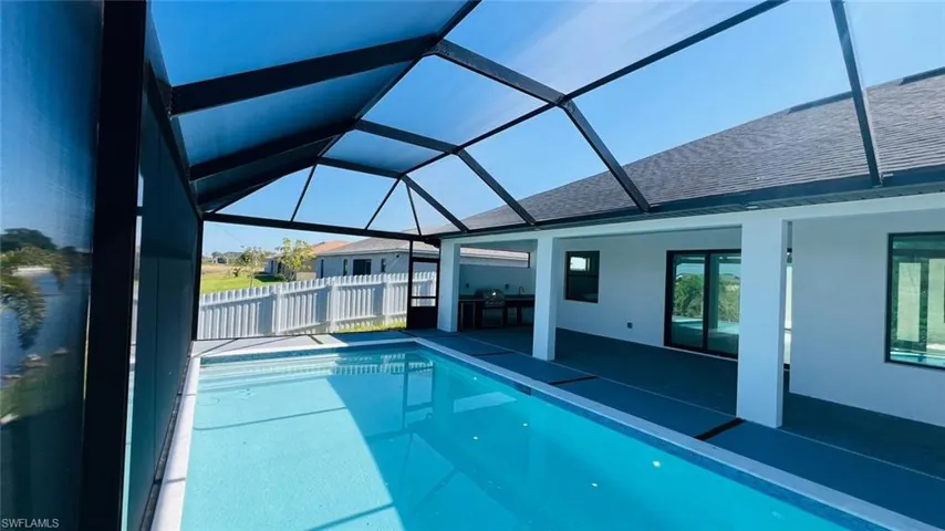Outdoor pool featuring a patio area and glass enclosure