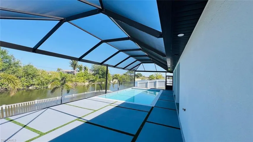View of tennis court featuring a water view and a patio