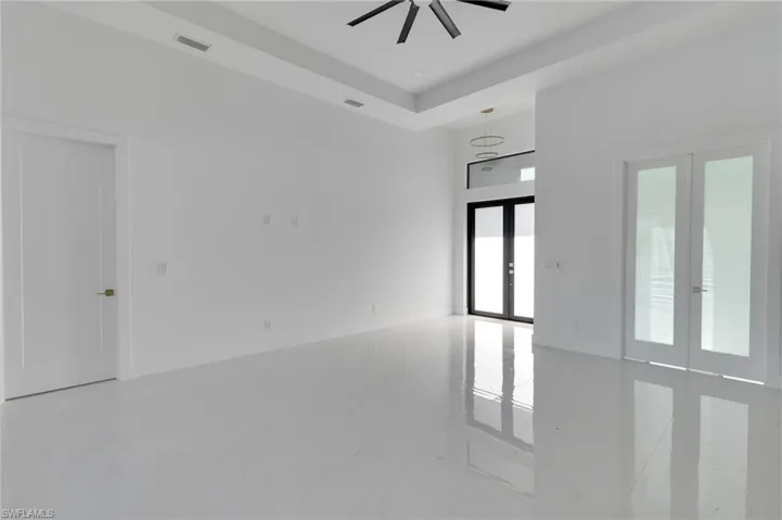 Spare room with french doors, a ceiling fan, and marble finish flooring