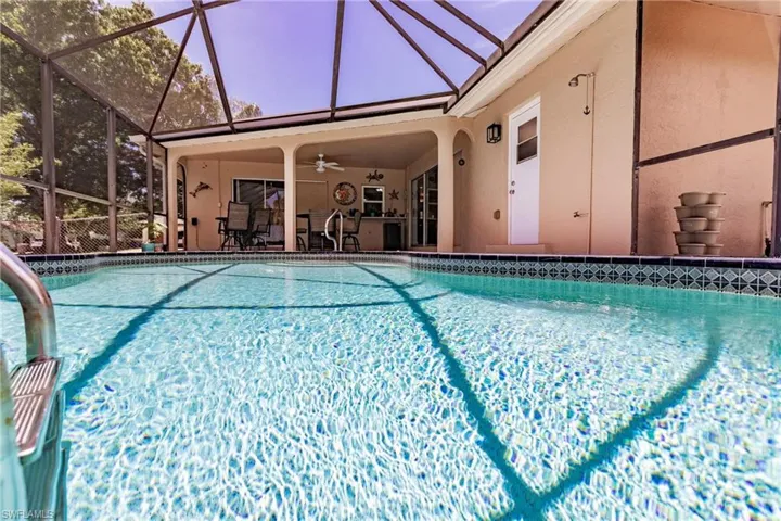 View of pool with a patio, a lanai, and ceiling fan