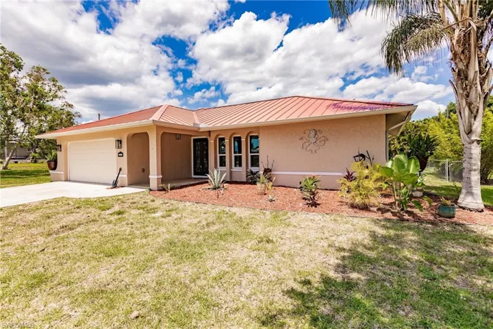 View of front of house featuring a garage and a front lawn