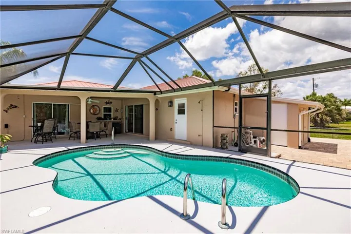 View of swimming pool featuring glass enclosure and a patio area