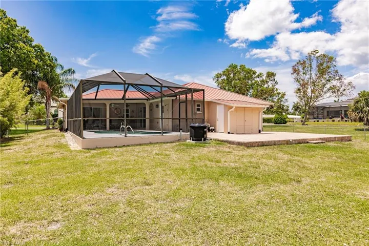 Back of house featuring a yard, a lanai, and a patio