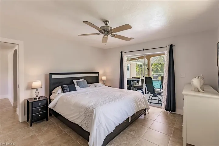 Bedroom with tile flooring, ceiling fan, and access to exterior
