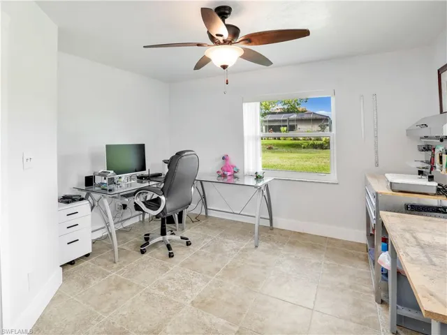 Office with ceiling fan and light tile floors