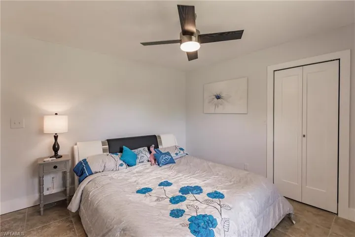 Tiled bedroom featuring a closet and ceiling fan