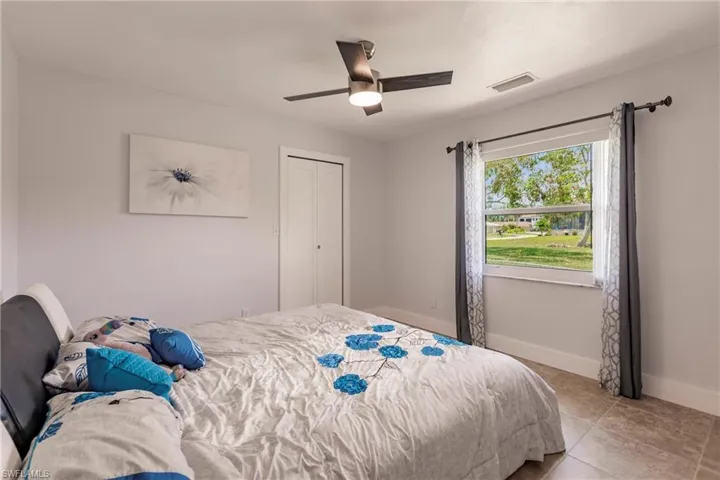 Bedroom featuring tile floors, ceiling fan, and a closet